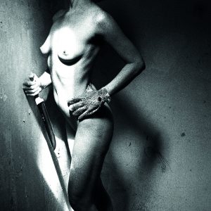 Schwarz-weiß Fotografie einer nackten Frau mit einem Handschuh an der linken und einem Messer in der rechten Hand