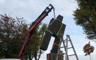 Ein Kran hebt eine Skulptur