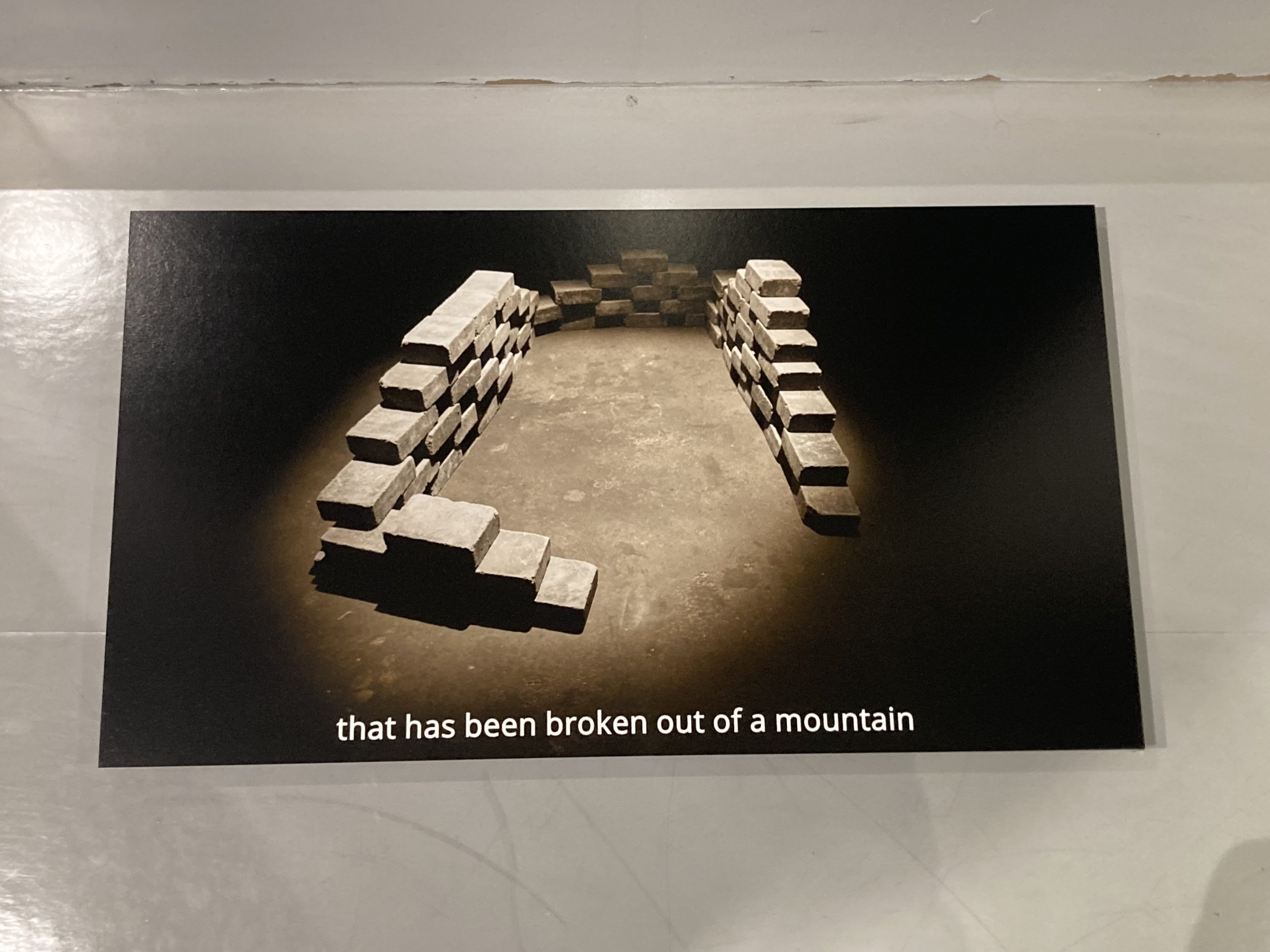 Eine zerstörte Steinmauer von oben mit der Schrift "that has been broken out of a mountain"