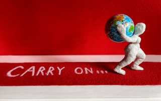 Eine Figur trägt die Weltkugel auf ihren Rücken.