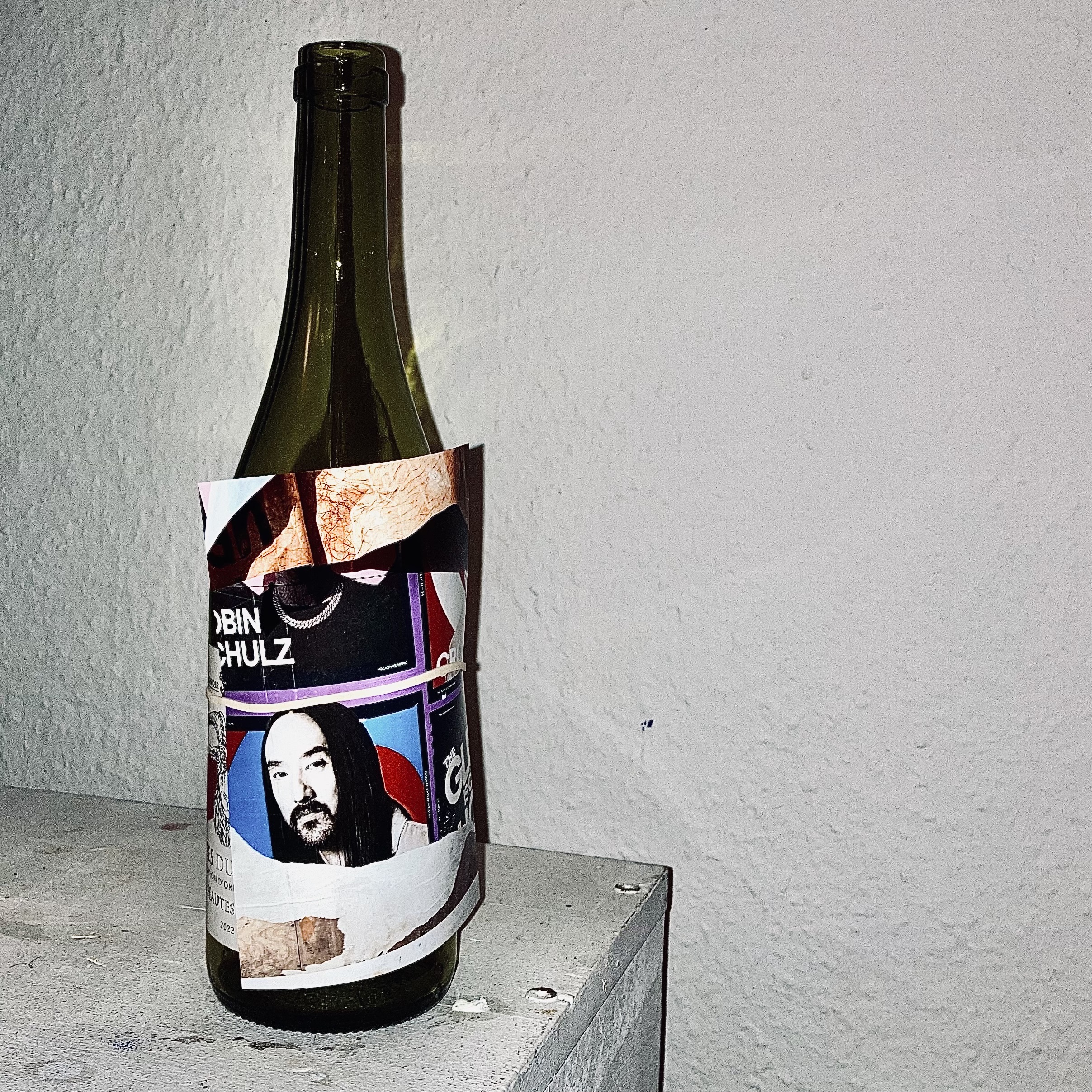 Eine Weinflasche ist mit einer Collage geschmückt